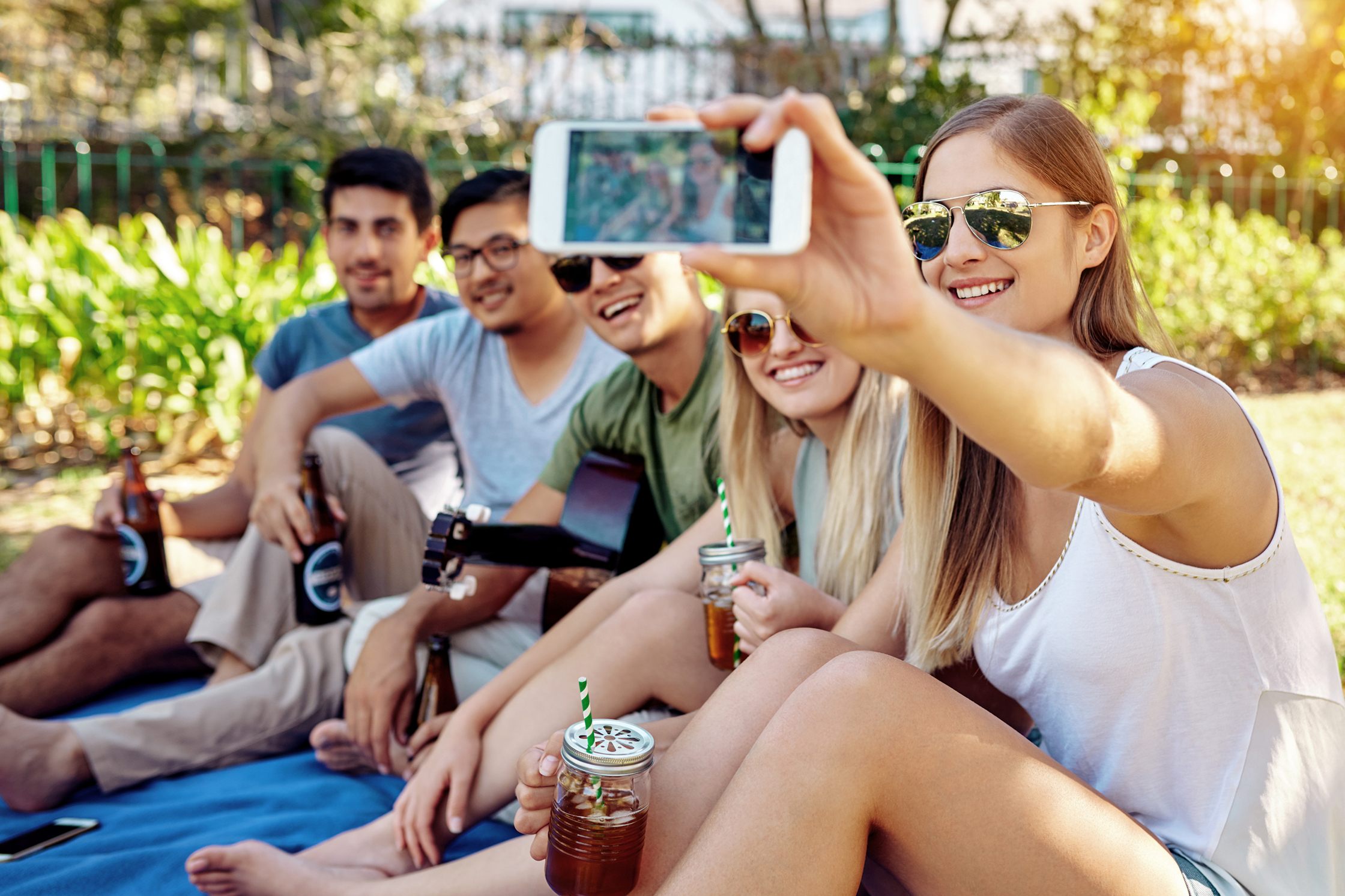 Junge Menschen feiern die Game Events mit kalten Getränken im Park.